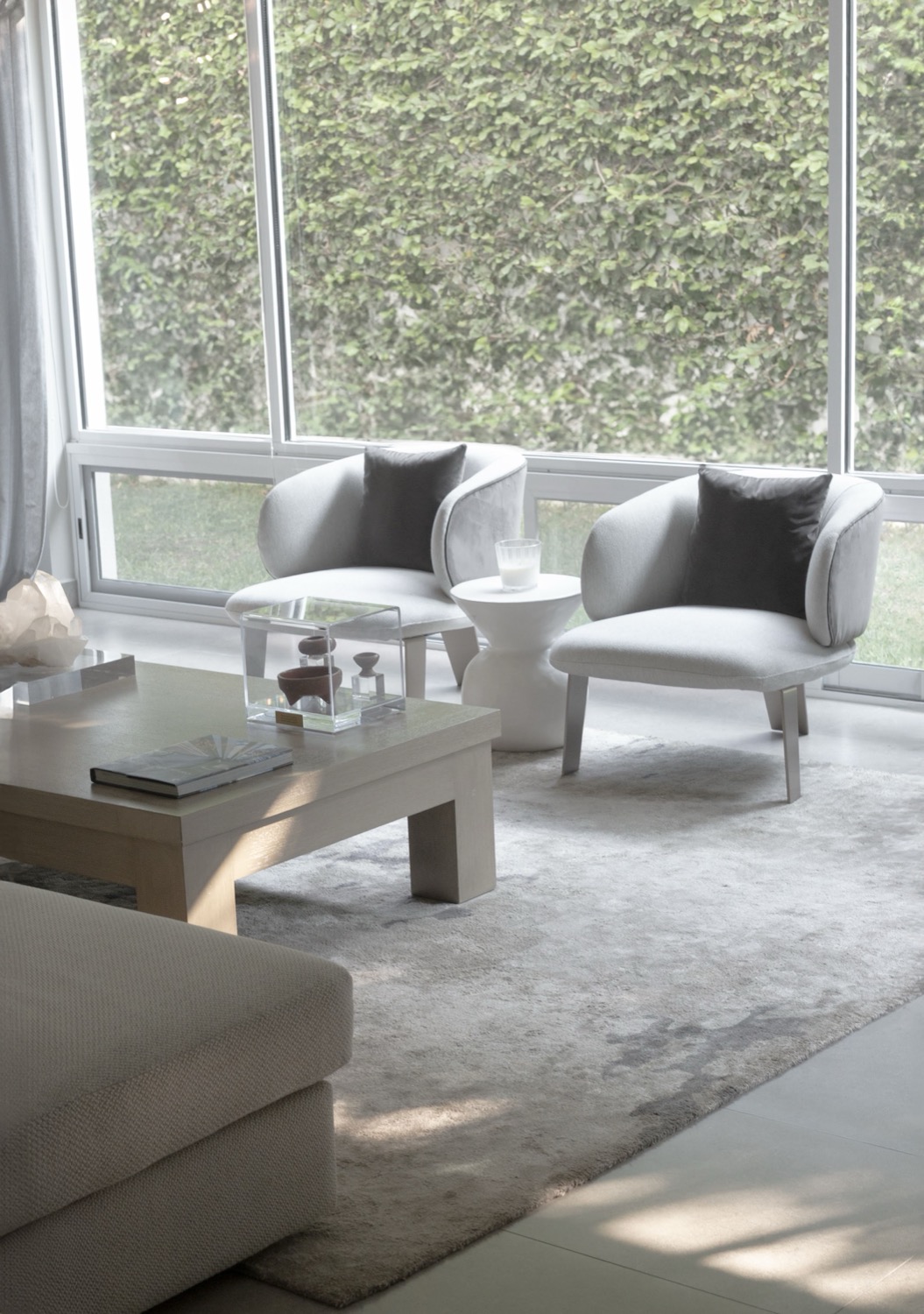 Agaves — living room with pale armchairs beside a full-height garden window